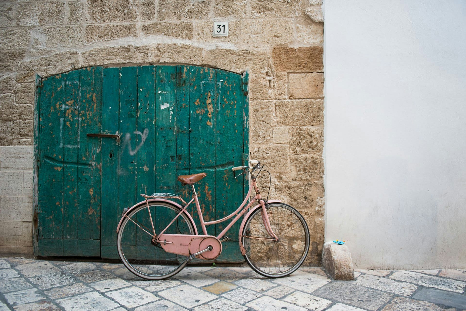Pink bicycle in front of a door in Italy.